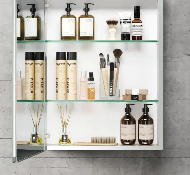 Elegant glass shelves inside a mirror cabinet with lights, offering a sleek and bright storage design for modern bathrooms.