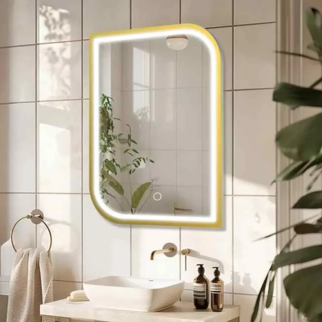 Framed LED bathroom mirror installed in a modern hotel bathroom