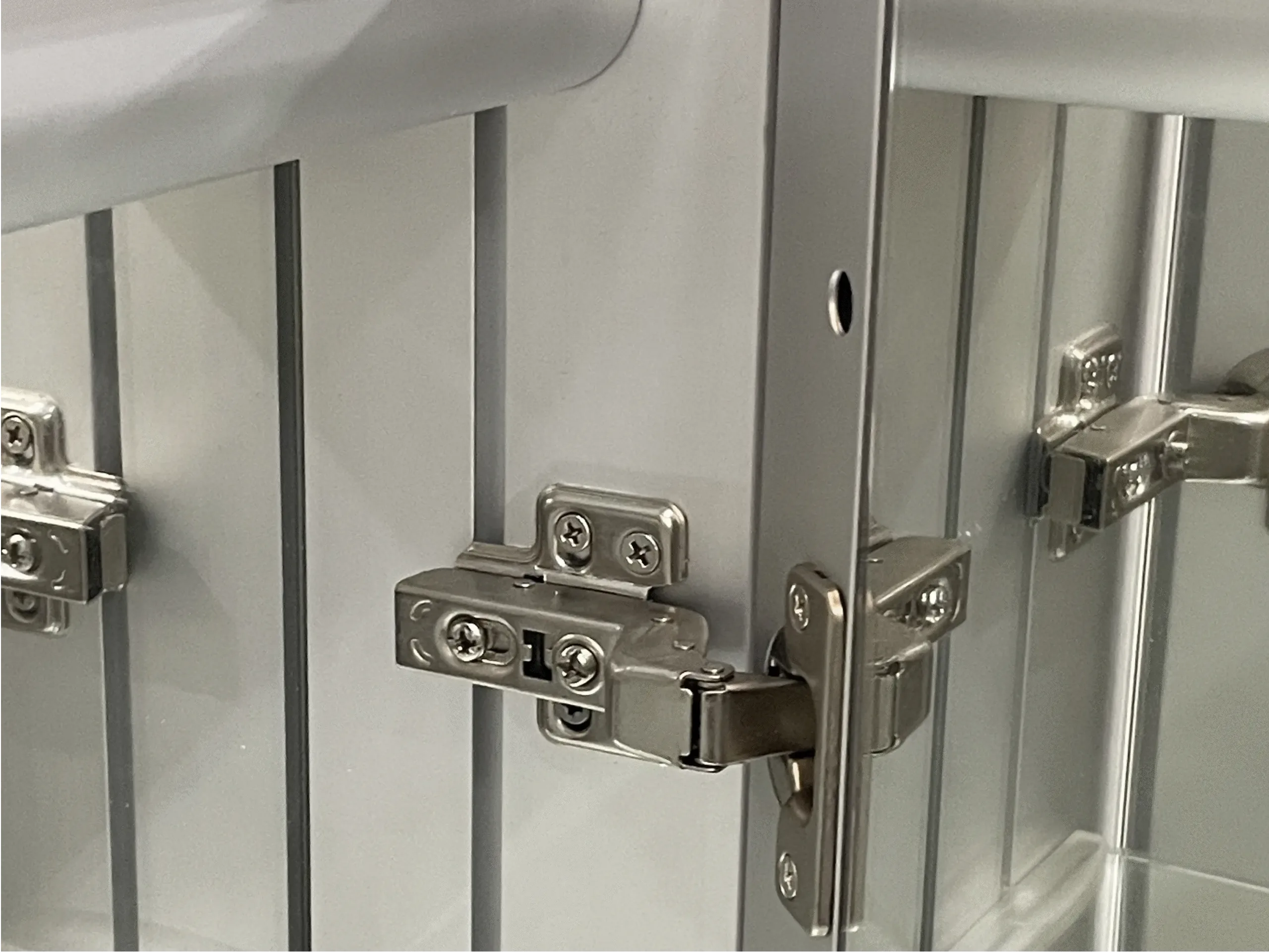 Close-up of a concealed hydraulic soft-close mechanism, one of the most reliable medicine cabinet hinges types for aluminum chassis.